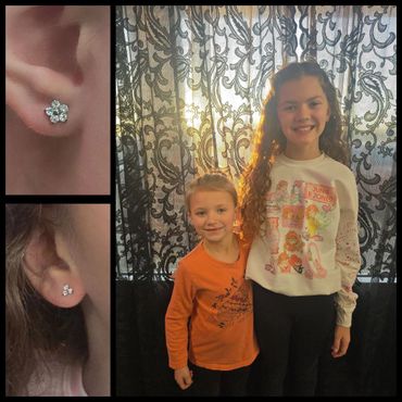 Two smiling kids with matching diamond stud earrings.