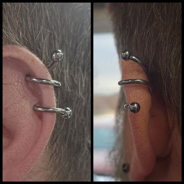 Close-up of a nose piercing with a silver hoop and ball ends from two angles.
