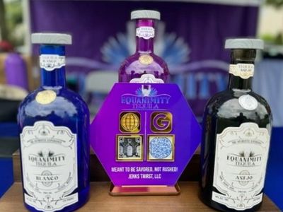 Three bottles of Equanimity Tequila, including Blanco, Añejo, and a purple hexagonal bottle.