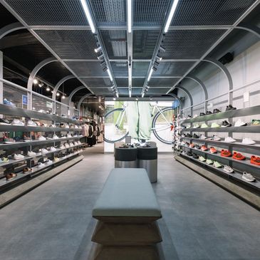 Modern shoe store interior with sleek shelves and seating.