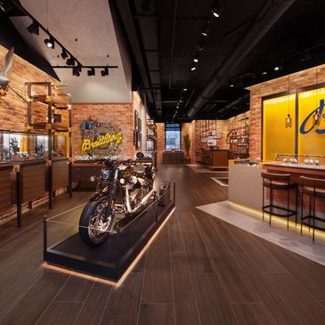 Vintage motorcycle displayed in a stylish, modern showroom with warm lighting.