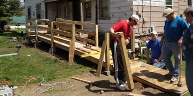 Group of people building a ramp on a house