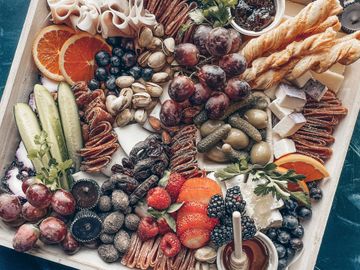A colorful charcuterie board with fruits, nuts, and cheeses.