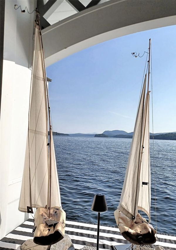 Voilier fait main, gros plan coque bois, voiles en tissu, sculpture navale.