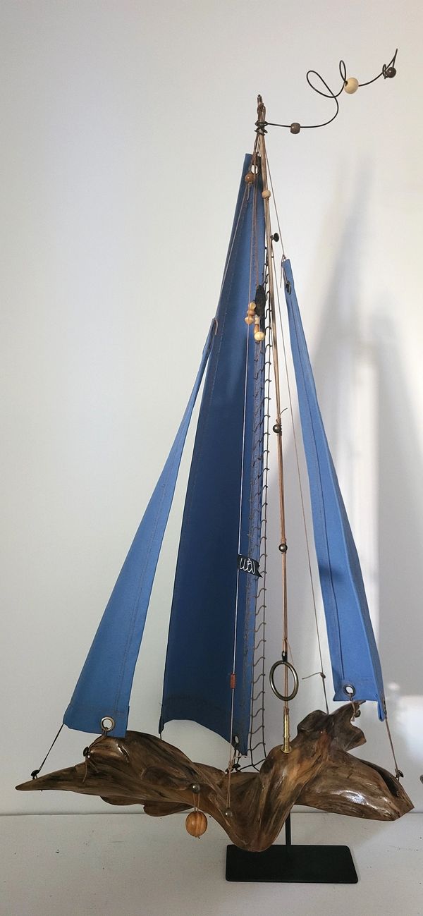 Voilier en bois sculpté décoratif sur une étagère dans un intérieur moderne. artiste, sculpteur.