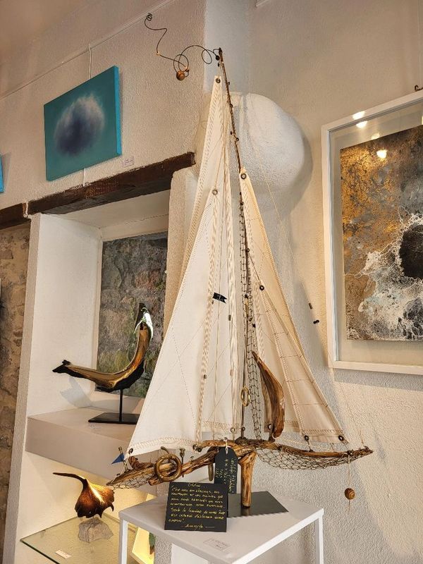 Artiste québécois sculpte voilier, atelier artisanat québécois.