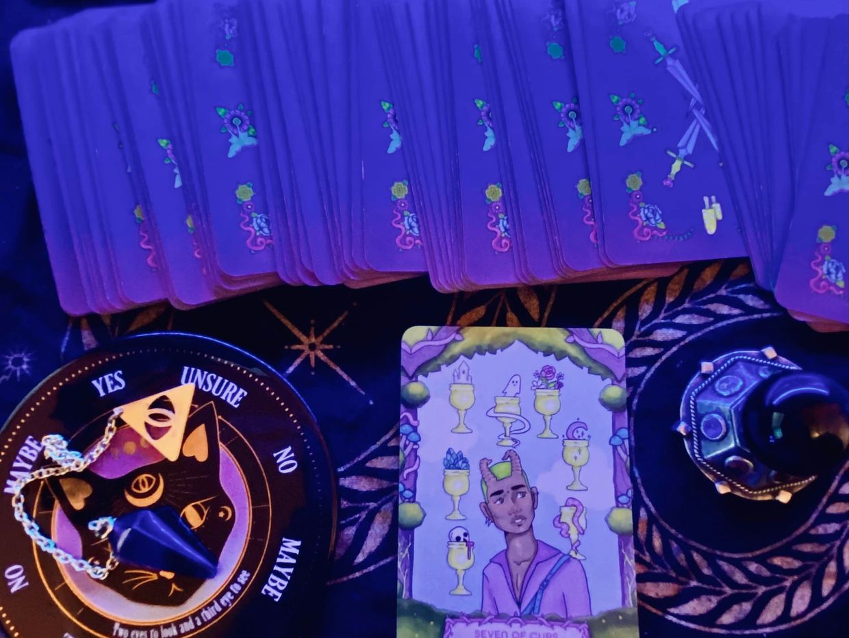 Tarot cards and a pendulum on a mystical cloth under blue light. psychic medium spiritual guidance tarot readings