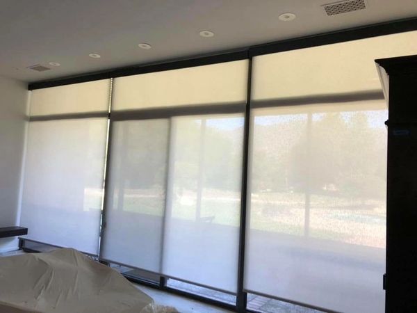 Motorized Roller Shades butted Up on a Wall of Windows.