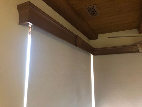 Motorized Roller Shades under a Wood Cornice.  One Roller is mounted above the other for the gap.