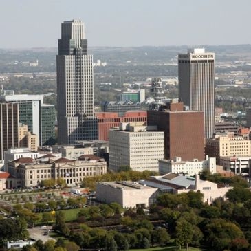 Skyline of a mid-sized city with tall buildings and greenery.