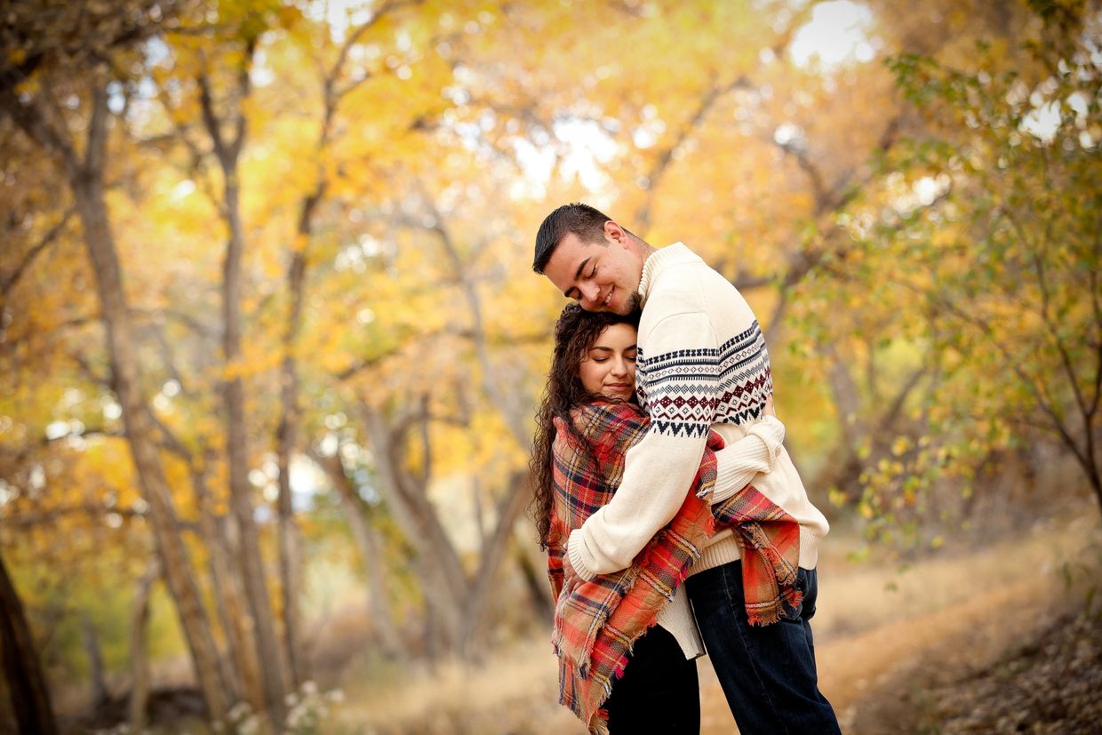 Beautiful couple embrace each other in a fall day.