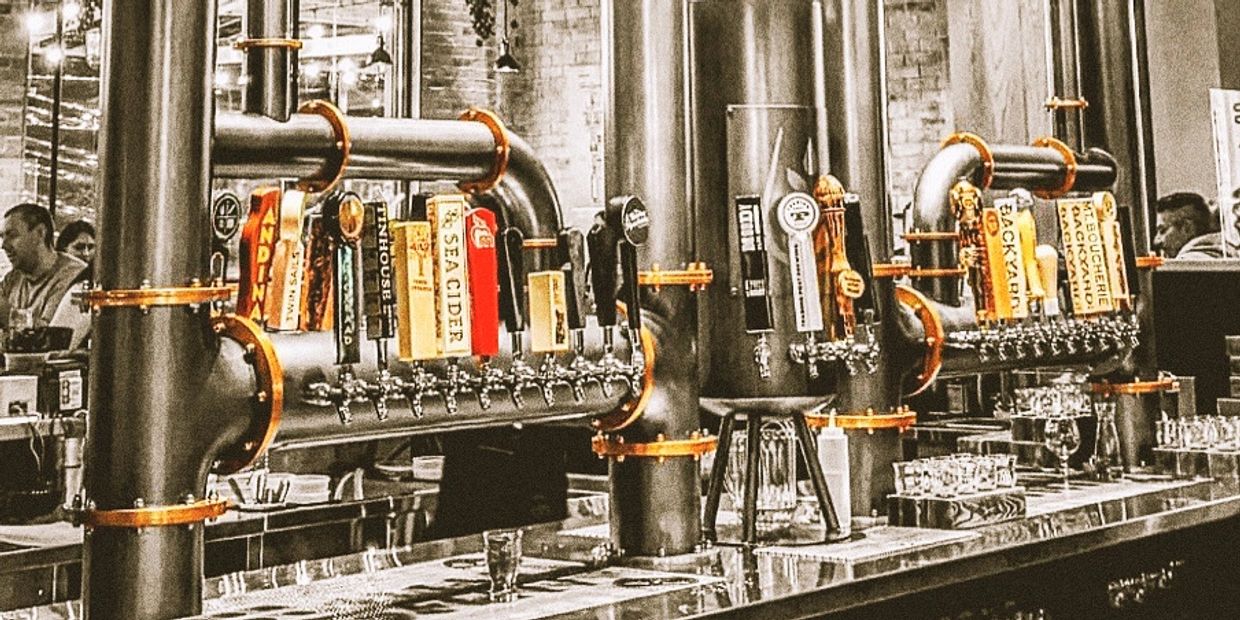 Bar beer taps with various labels at a brewery.