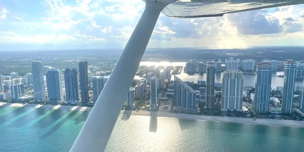 A photo of Miami coastline captured from the air, under the wing of a Cessna 172.