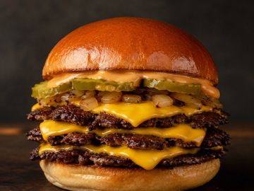 Triple cheeseburger with pickles and sauce.