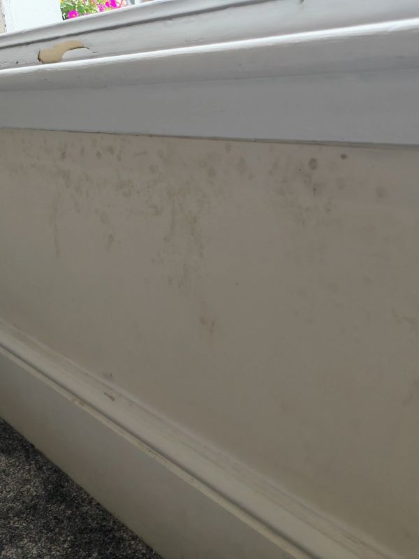 Wall beneath window with stains and marks.