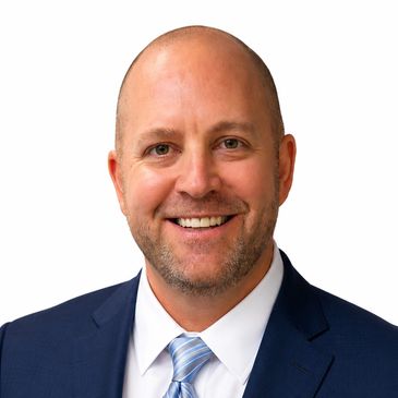 Smiling bald man in a suit and tie.