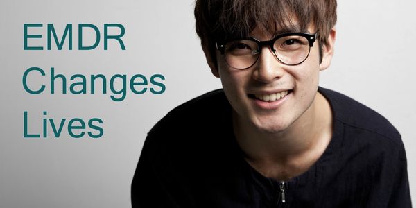 Young adult wearing glasses and smiling. Text in photo says "EMDR Changes Lives."