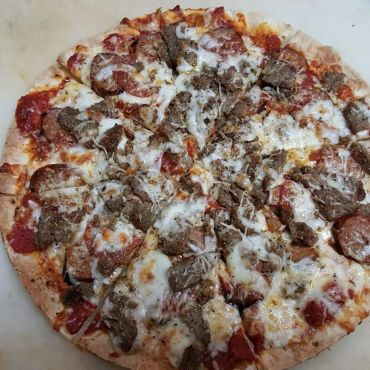 A picture of pizza topped with cheese and chicken 