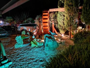 Giardino illuminato di notte con ruota idraulica.