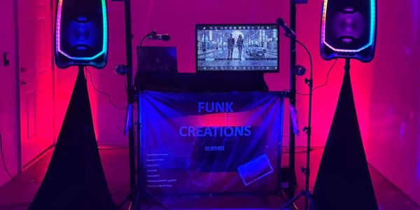 DJ setup with vibrant pink and purple lighting and speakers.