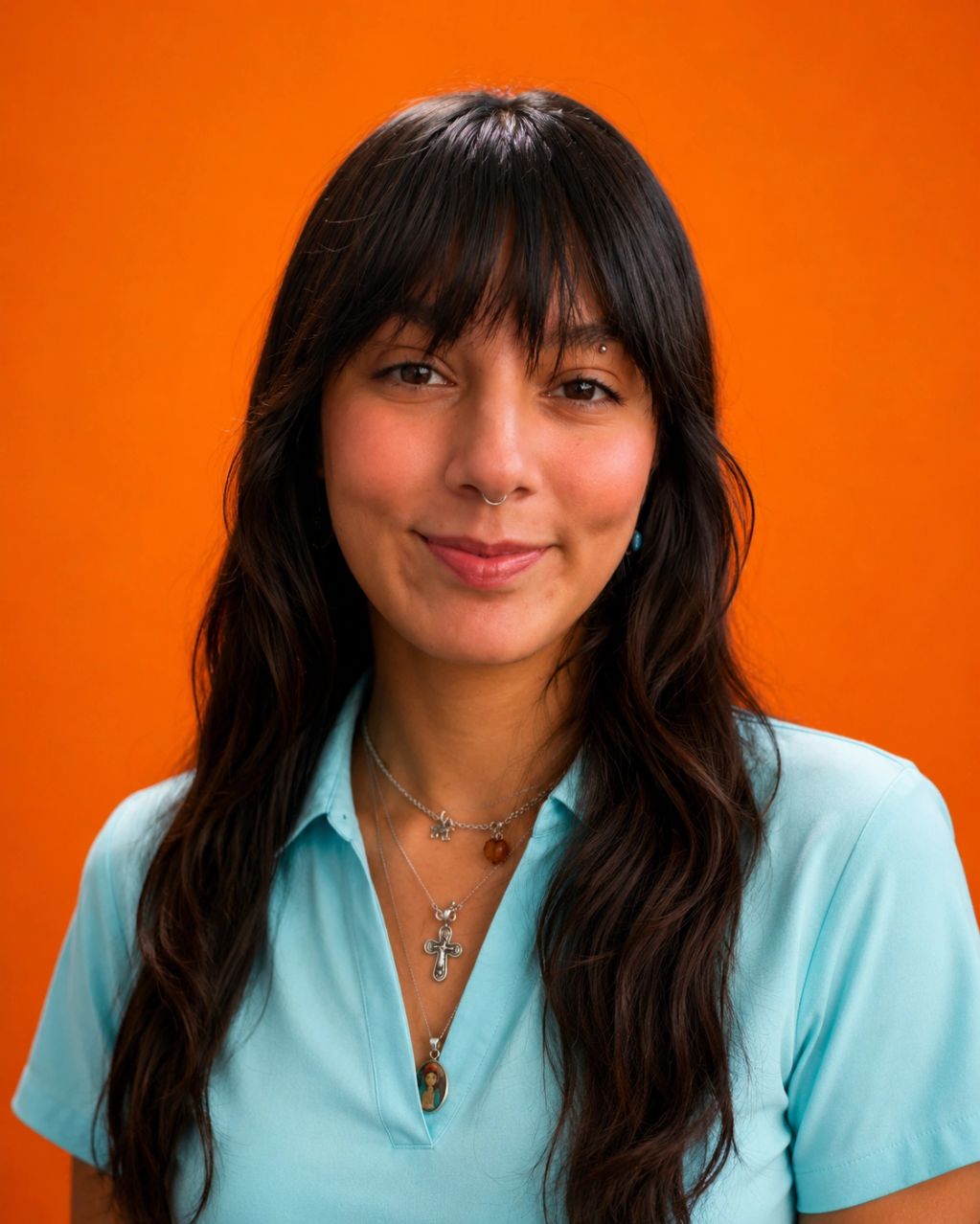 Young woman with long dark hair against an orange background.