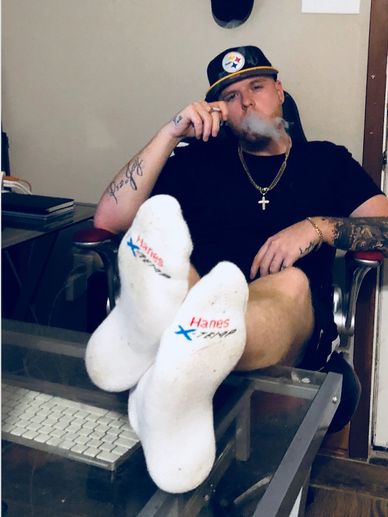 Man in black shirt relaxing and smoking indoors.