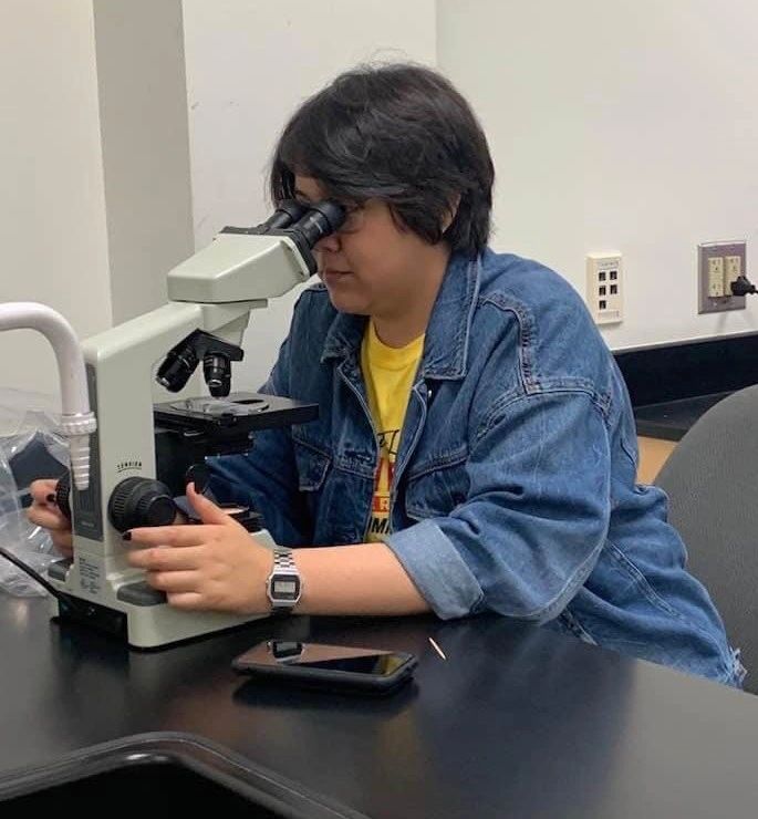 A Person Looking Through the Microscope