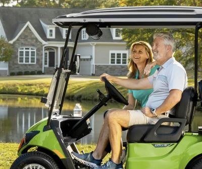 two happy people riding in a golf cart