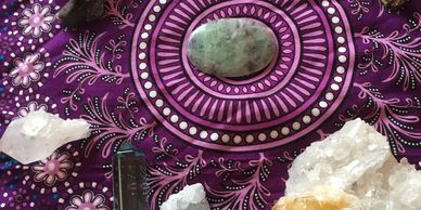 Close up of purple cloth with stones and crystals on it.
