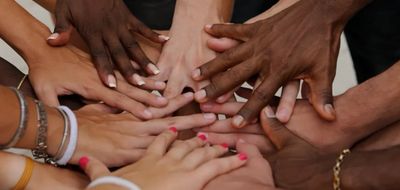 Diverse group of hands joined together in unity and support.