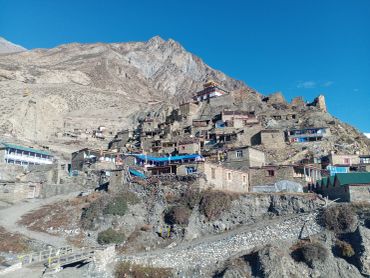 Mountain village with traditional stone houses and a temple.