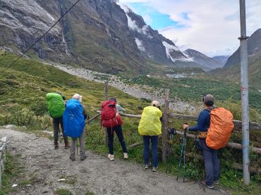 Group of hikers with backpacks overlooking mountainous valley.