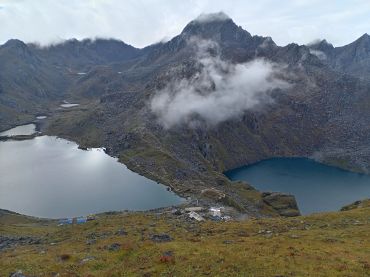 Mountainous landscape with lakes and fog.