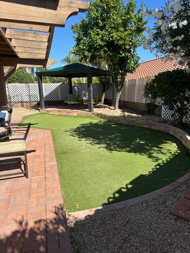 Backyard with gazebo and artificial grass.