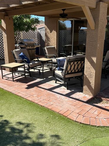 Shaded patio seating area with chairs and tables.