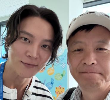 Two men posing for a selfie indoors.