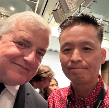 Two men posing for a selfie indoors.