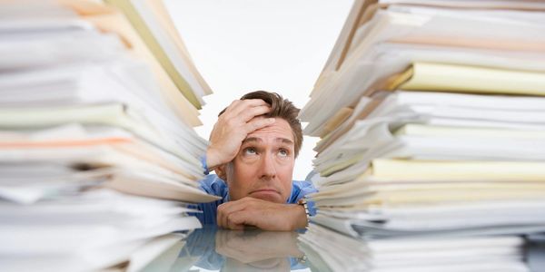 A man is surrounded by Paper ready for Confidential Shredding