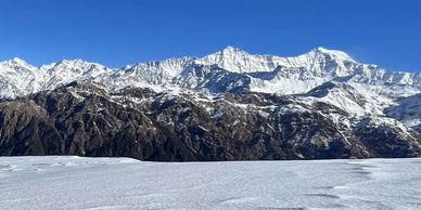 Snow-covered mountain range under a clear blue sky.