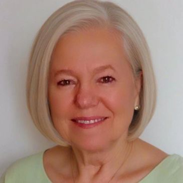 Smiling elderly woman with short silver hair.