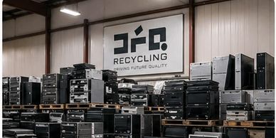 Stacks of old computer towers in a recycling facility.