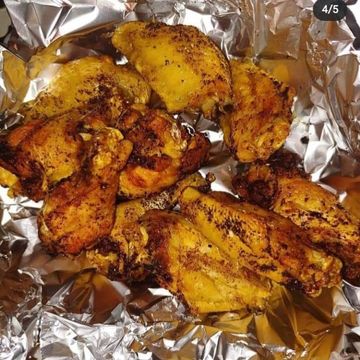 Grilled chicken wings seasoned and cooked on foil.