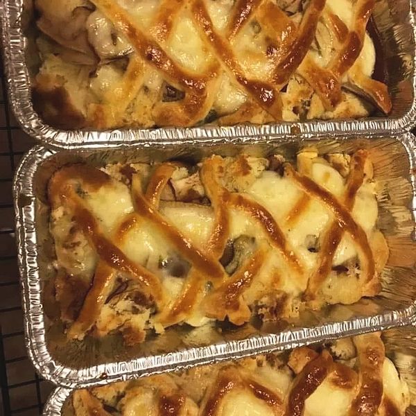 Three foil trays with lattice-topped baked dishes.