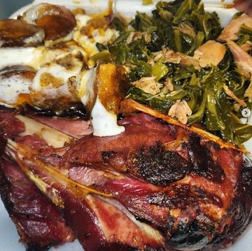 Plate of smoked ham, collard greens, and yams with marshmallows.