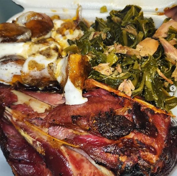A plate with smoked ribs, creamy sweet potatoes, and seasoned collard greens.