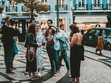 Group of people socializing on a patterned street in an urban setting.