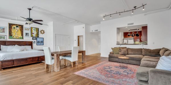 Modern open-concept living space with wooden floors and neutral tones.