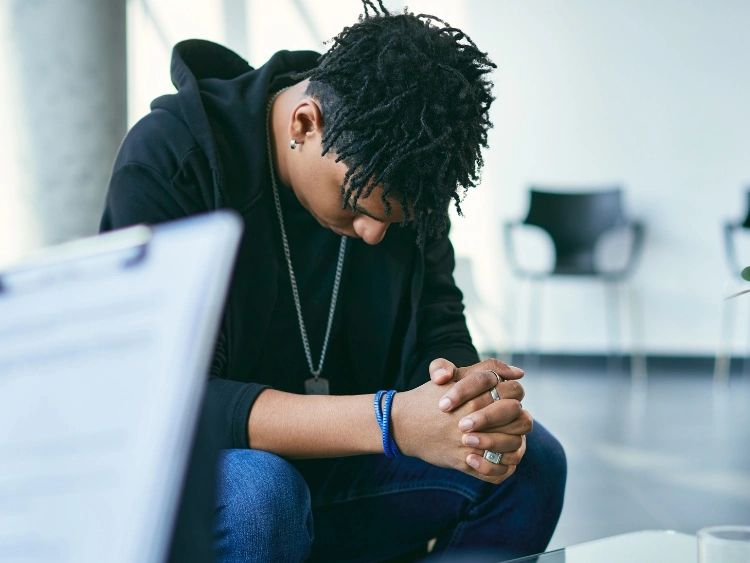 Man sitting in therapist office getting help with depression counseling.