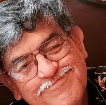 Smiling elderly man with glasses and a mustache.