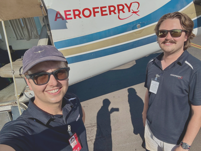 Two men smiling beside an AeroFerry plane.
